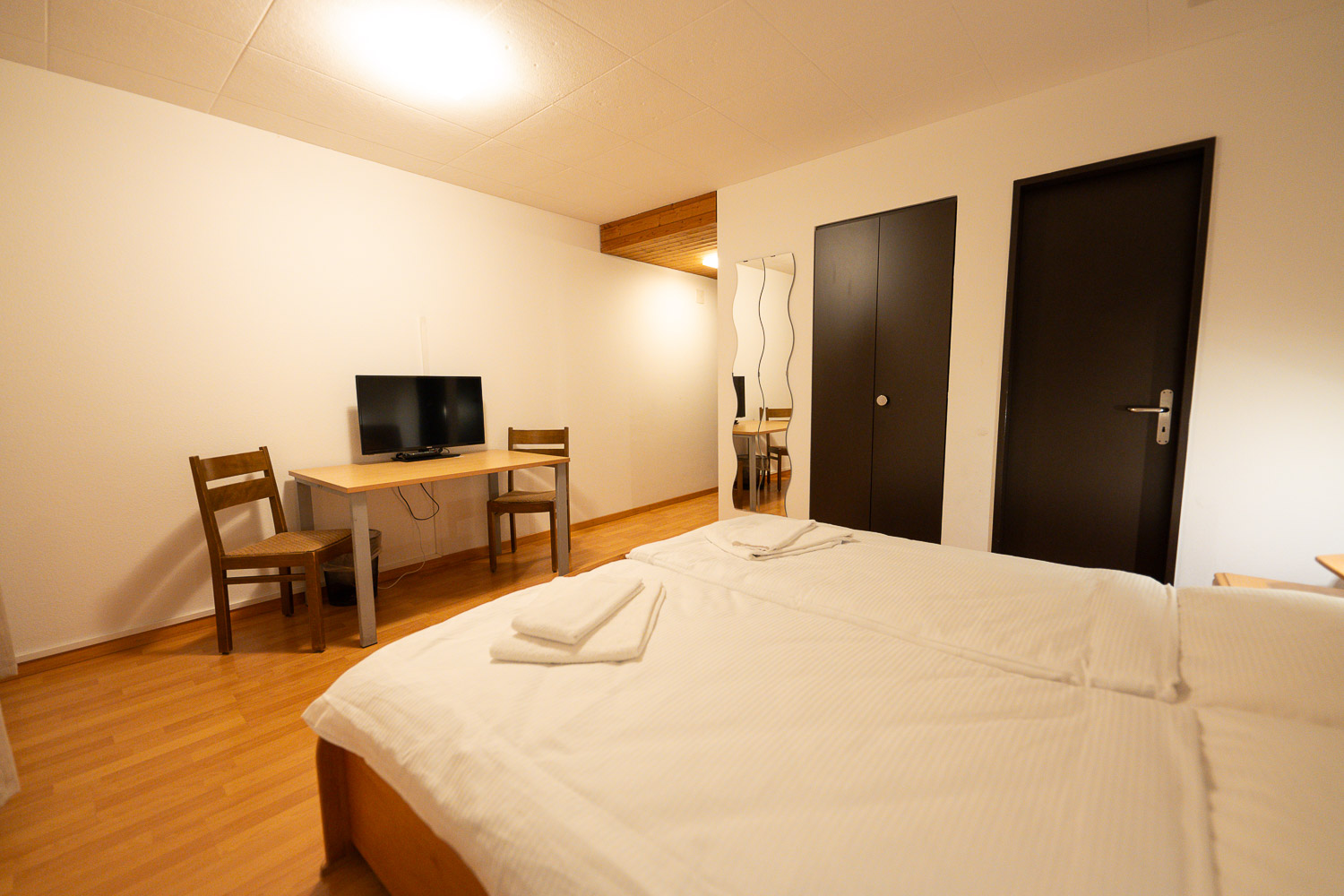 Doppelzimmer mit Schreibtisch und Fernseher