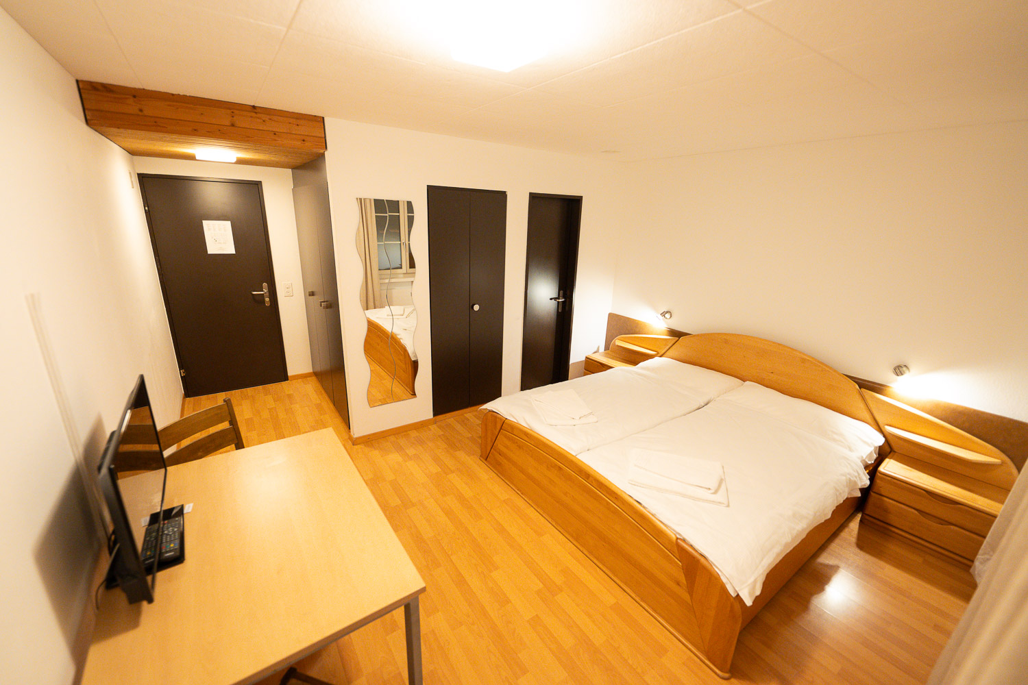 Doppelzimmer mit Bett, Schrank und Schreibtisch