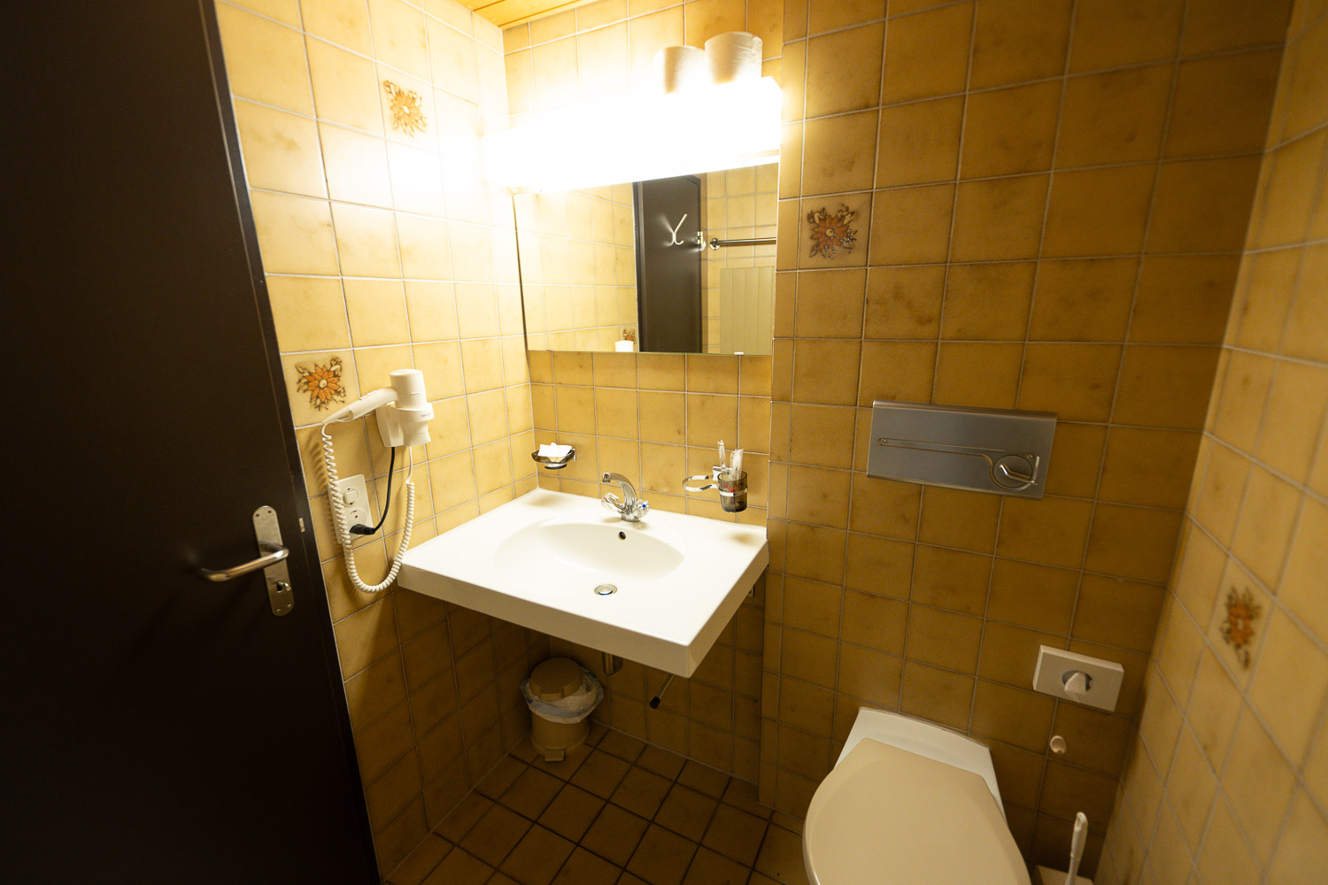 Lavabo, Spiegel und Haartrockner im Dreibettzimmer
